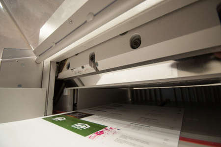 Close-up on a steel knife of a paper cutting machine in a printing factory.