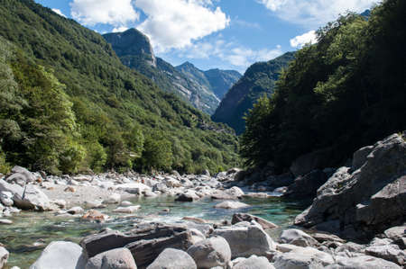 Verzasca Switzerland, a deep valley in the mountains with a river flowing over large bouldersの写真素材