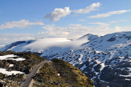 Snow-capped mountains and roads on rocky cliffs in northern Europe in Norway above the town of Geiranger.の写真素材