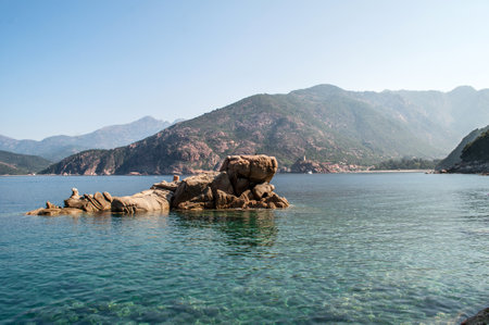 The sea level from which the orange stones rise. Rocky sea coast and mountainous landscape on the island of Corsica in France.の写真素材