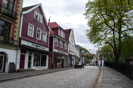 Bergen, Norway - May 22, 2016: Street with cobbled road and wooden houses with shops in the city center.のeditorial素材
