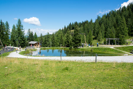 Mountain lake with children's playground in the background. Grafenberg Hill, Wagrain, Austria.のeditorial素材