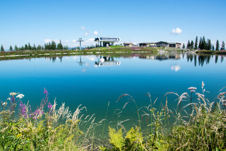 Wagrain, Austria - Upper station of the Grafenberg cable car, Wagrain in the Austrian Alps with a lake and blooming flowers.のeditorial素材