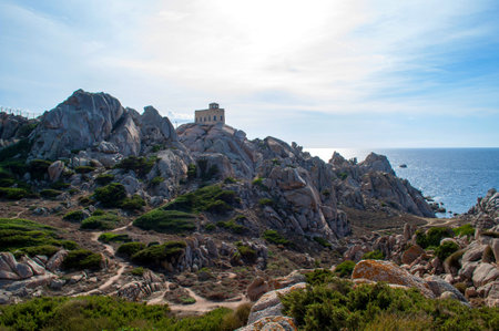 Rocky sea coast with a lighthouse in the Capo D'Orso area on the island of Sardinia, Italyの写真素材