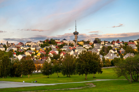 City park in Trondheim, Norway in the evening at sunset. High tower and city skyline with wooden colorful houses.の写真素材