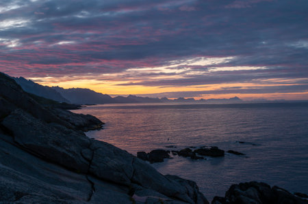 Sunset and rock mountains on the sea coast in a bay on the Lofoten Islands in Norway.