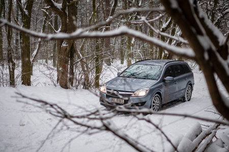 Brno, Czech Republic - December 28, 2012: Gray Opel Astra car in winter in the snow in the forest...