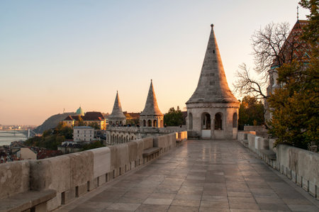Old buildings with towers illuminated by the setting sun and stone pavement on the promenade of the Fisherman's Bastion in Budapest, Hungaryのeditorial素材