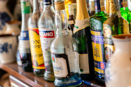 Sobeslav, Czech Republic - Alcohol bottles placed next to each other in a row at a bar. Glasses with...