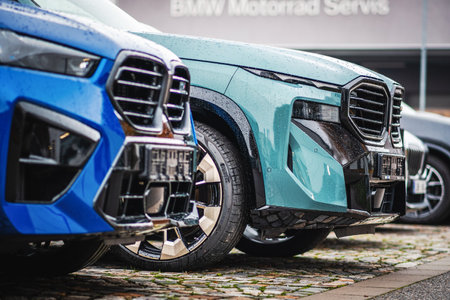 Brno, Czech Republic - November 25, 2023: Detail of the front of two modern BMW XM electric vehicles with a black grille and front lights.のeditorial素材