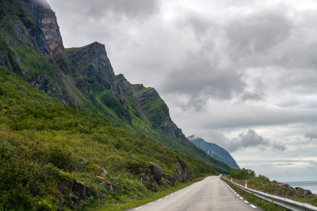Road on the coast of a fjord in Norway under high mountains and rocks. Scandinavian road along the cliffs.の写真素材
