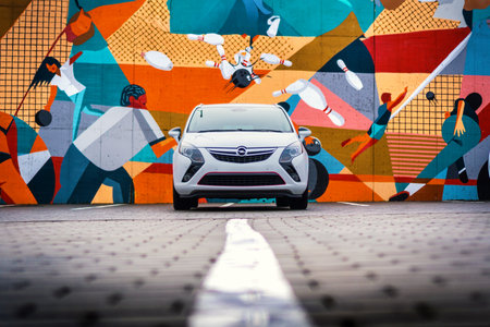 Brno, Czech Republic - February 15, 2024: White Opel Zafira Tourer MPV family car in a parking lot in front of a colorful painted wall. Zafira C front view.のeditorial素材