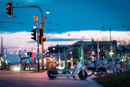 Brno, Czech Republic - March 18, 2024: Shared bikes and Lime electric scooters at night in the city.のeditorial素材