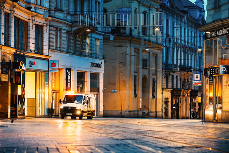Brno, Czech Republic - March 18, 2024: Empty street in the city in the early morning lit by shop windows. Historic city center in Europe.のeditorial素材