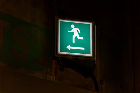 Luminous emergency exit sign in a tunnel. Safety feature in the dark in case of danger.の写真素材