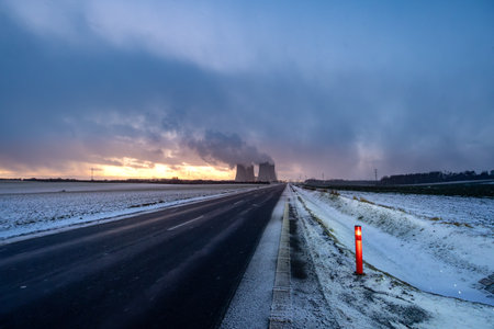 Dukovany, Czech Republic - December 29, 2025: Cooling towers of the Dukovany nuclear power plant. Large smoking cooling towers in the evening in winter at sunset.のeditorial素材