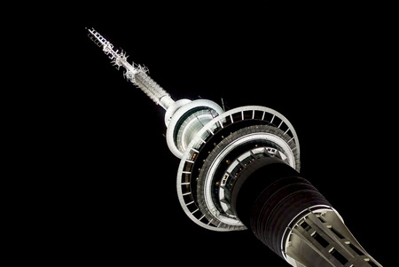 Auckland Sky Tower at Night showing the top of the tower in a black night sky and taken on an angle to give a semi abstract interpretation. It is the highest building in New Zealandのeditorial素材