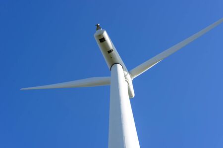 The windfarms near Wellington on the west coast at Makara, the pylons stand tall among green farmland and grazing sheep, generating power for Wellington and New zealandの写真素材