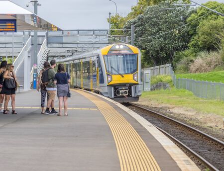 Auckland, New Zealand December 12 2015 Auckland's Orakei railway station on the Eastern Line. People waiting for the train to stop as it approachesのeditorial素材