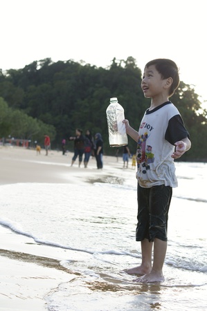 Happy asian boy playing at the beach の写真素材