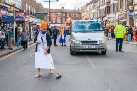 Devotees remove their shoes to sweep the road clean take part in the festival of Vaisakhi, celebrating the birth of Sikhsのeditorial素材