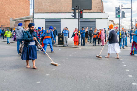 Devotees remove their shoes to sweep the road clean take part in the festival of Vaisakhi, celebrating the birth of Sikhsのeditorial素材