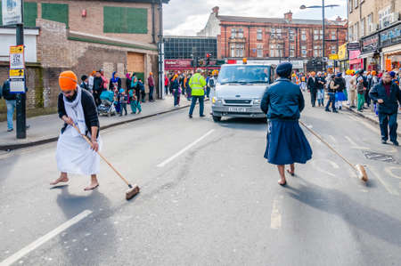 Devotees remove their shoes to sweep the road clean take part in the festival of Vaisakhi, celebrating the birth of Sikhsのeditorial素材