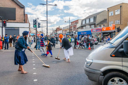 Devotees remove their shoes to sweep the road clean take part in the festival of Vaisakhi, celebrating the birth of Sikhsのeditorial素材