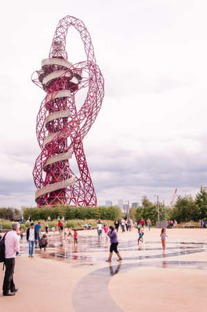 Children play in the water fountain to cool off in a summer heatwave at Queen Elizabeth  Park, 
Arcelor Mittal Orbit tower
in the background Stratford, Londonのeditorial素材