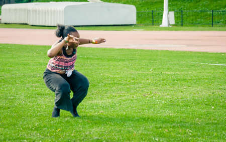 A female dance moves all parts of the body. Angular bending of arms, legs, and torso; shoulder and hip movement; scuffing, stamping, and hopping steps; asymmetrical use of the body a of African dance.の写真素材