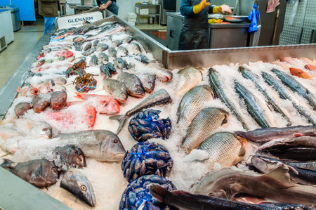 London, United Kingdom, 04 May, 2021: Queens Market covered shops, ethnically diverse, selling a mix of household objects, fish and exotic vegetables.のeditorial素材