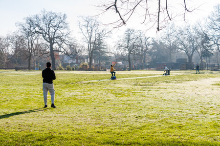 London, United Kingdom, 22 January 2023: People cricket playing winter in the park cold, frosty in a sunny day in the Morningのeditorial素材