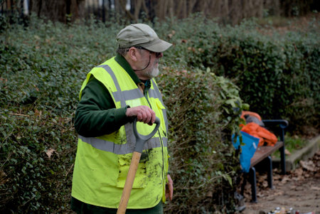 London, United Kingdom, 12 February 2023: Man volunteers in park working on overgrow on Dipping Pondのeditorial素材