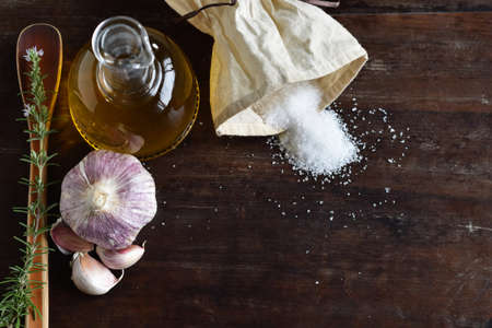 Salt, olive oil and garlic on wooden backgroundの写真素材