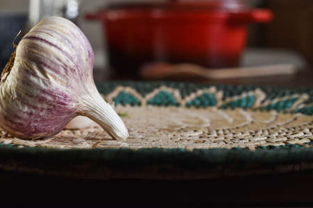 organic ingredient: fresh garlic on rustic wood. in the background, out of focus, olive oil bottle and red pan. Selective focus.の写真素材