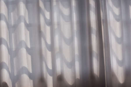 White abstract wavy curtain in front of the windowの写真素材