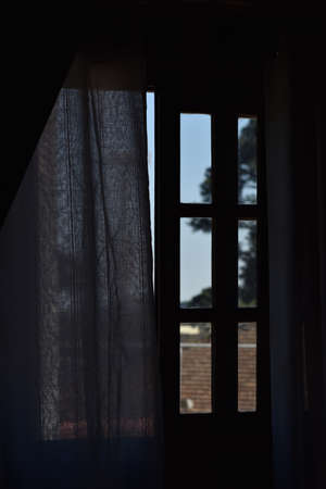white curtain in front of window with garden background in sunny dayの写真素材