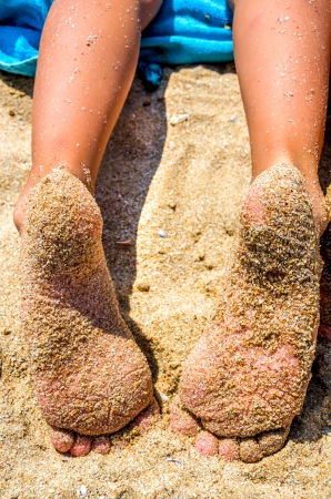 two children's feet in sand on the beachの写真素材