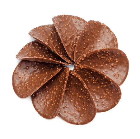 Chocolate nut chips in shape of flower isolated on white background の写真素材