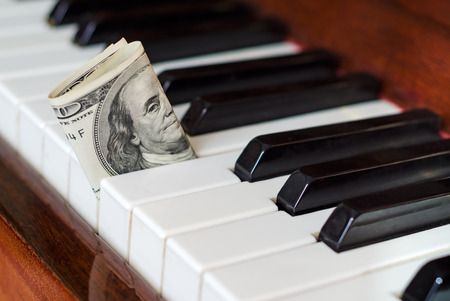 One hundred dollar bill stuck in a piano. Franklin stare. Earn from music.の写真素材