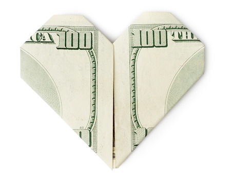 Hundred dollars folded into heart isolated on white background. Valentine's heart.の写真素材