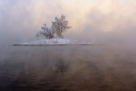 A small island with trees, barely visible in the fogの写真素材