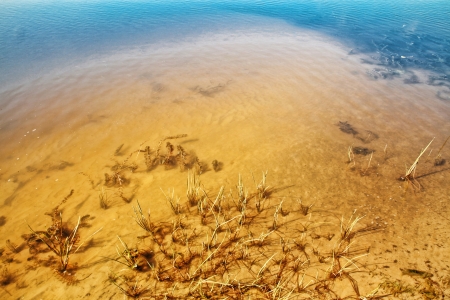 Yellow sand and dark blue water and sunの写真素材