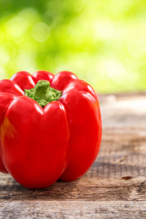Fresh red pepper on wooden table on nature backgroundの写真素材