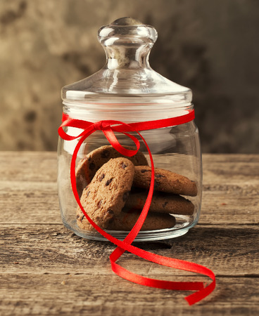 Cookies in a jar decorated with a red ribbonの写真素材