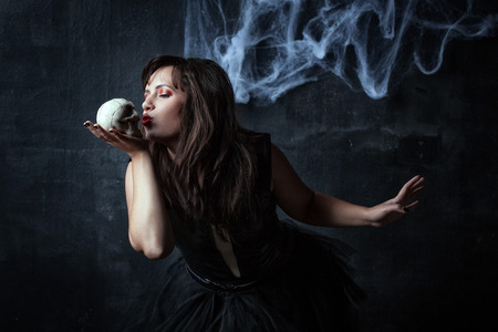 girl kissing small white skullの写真素材