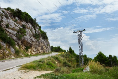 power line in the mountains near the road in Croatiaの写真素材