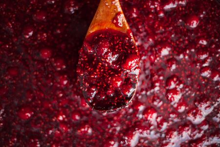 raspberry jam is kept with a wooden spoonの写真素材