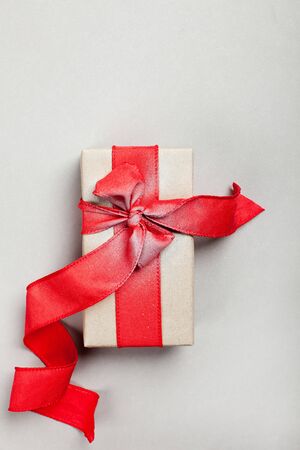 elongated gift box with a red ribbon on a gray background. blank for postcard, poster.の写真素材