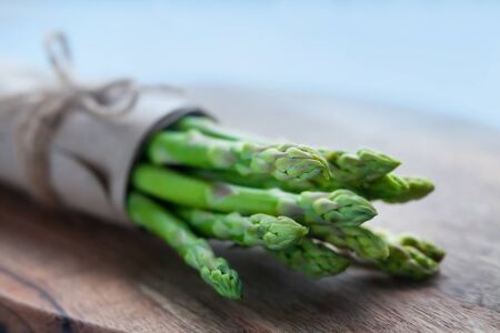 bunch of fresh green asparagus on a wooden background.の写真素材